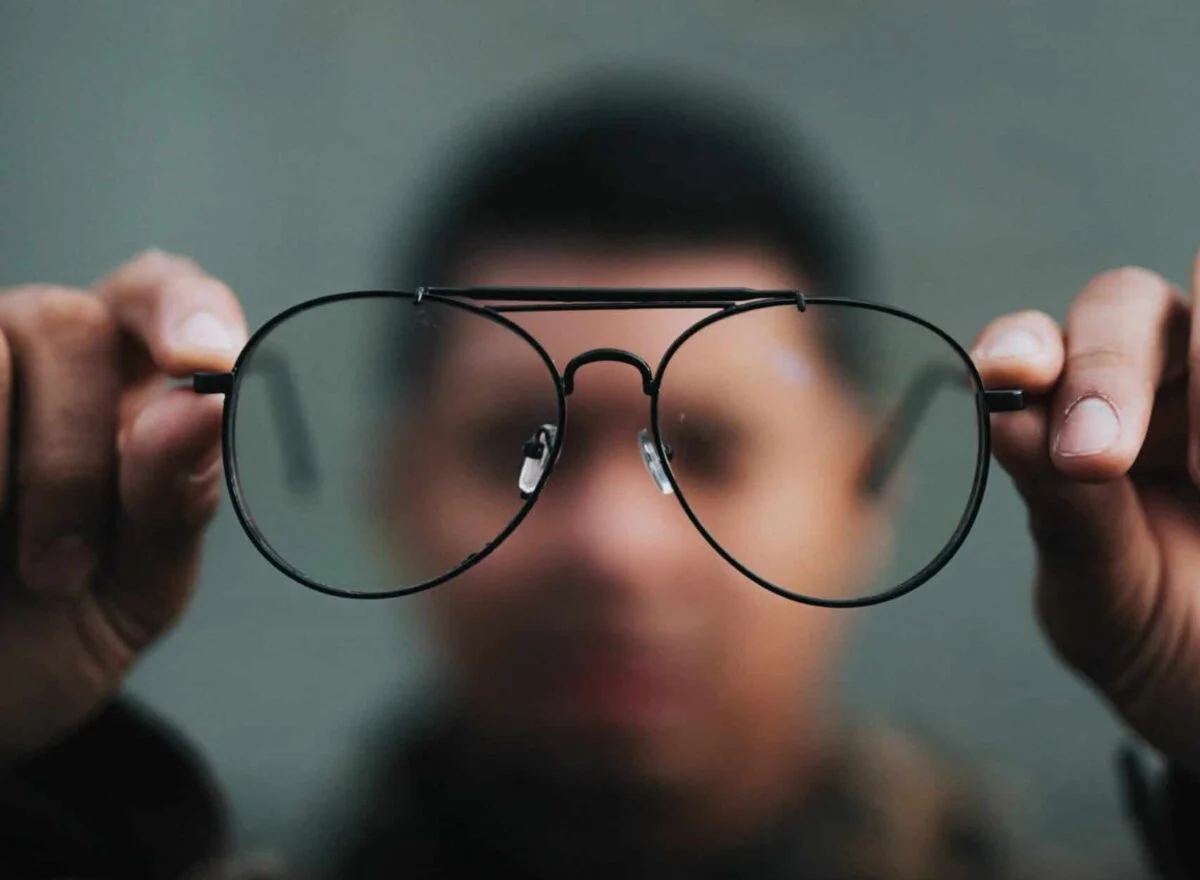man holding eyeglasses